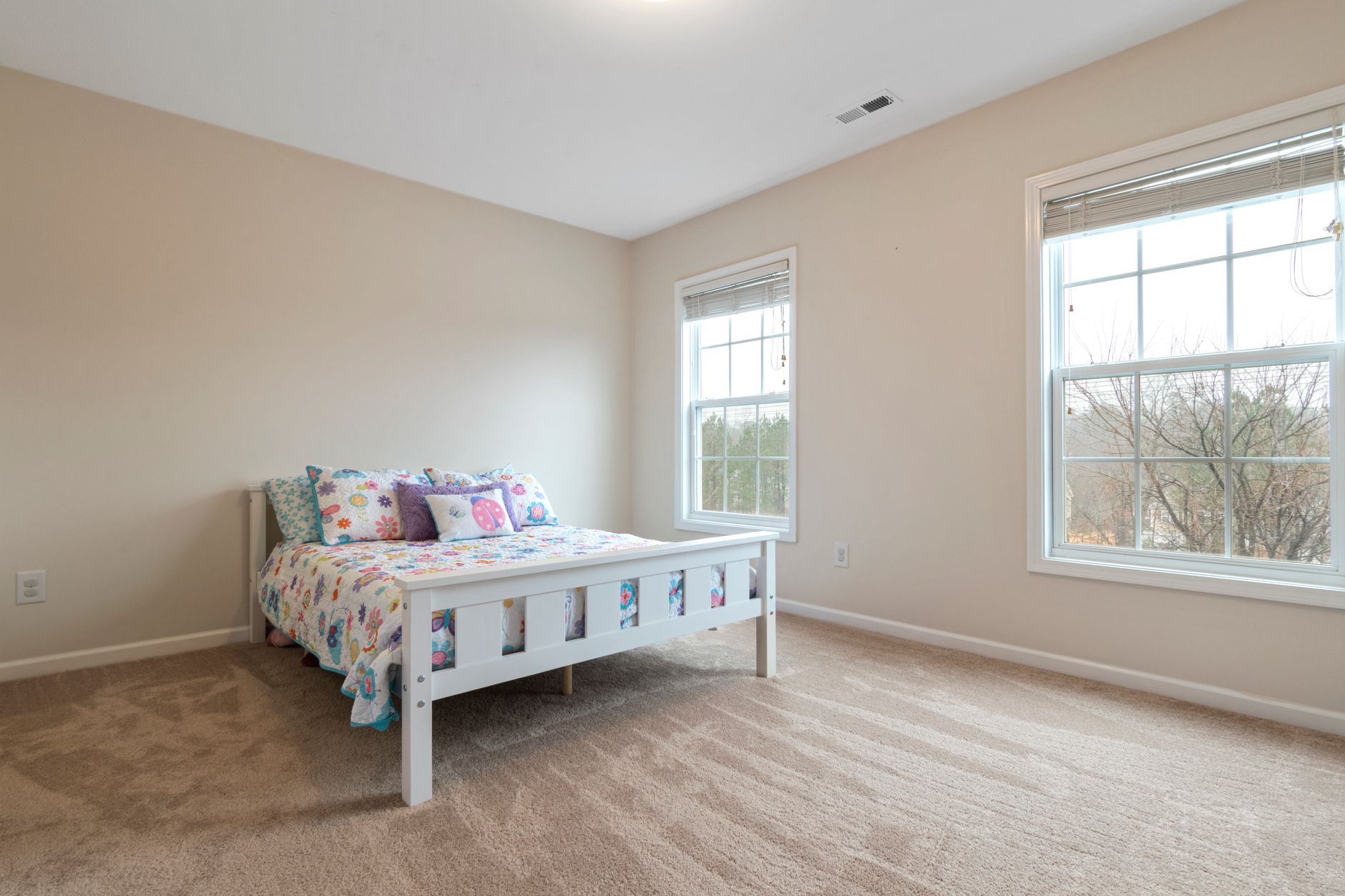 A mother sitting quietly in her child's empty bedroom after college move-in
