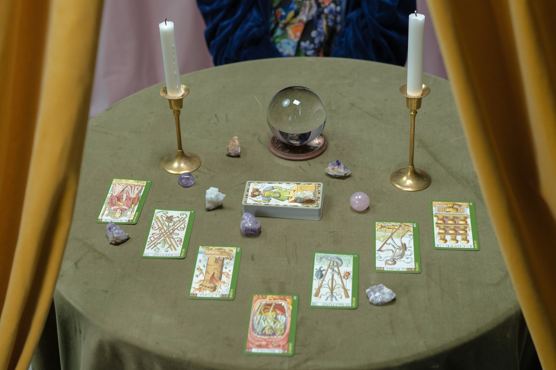 Tarot cards and a lit candle on a table, set for a psychic medium reading