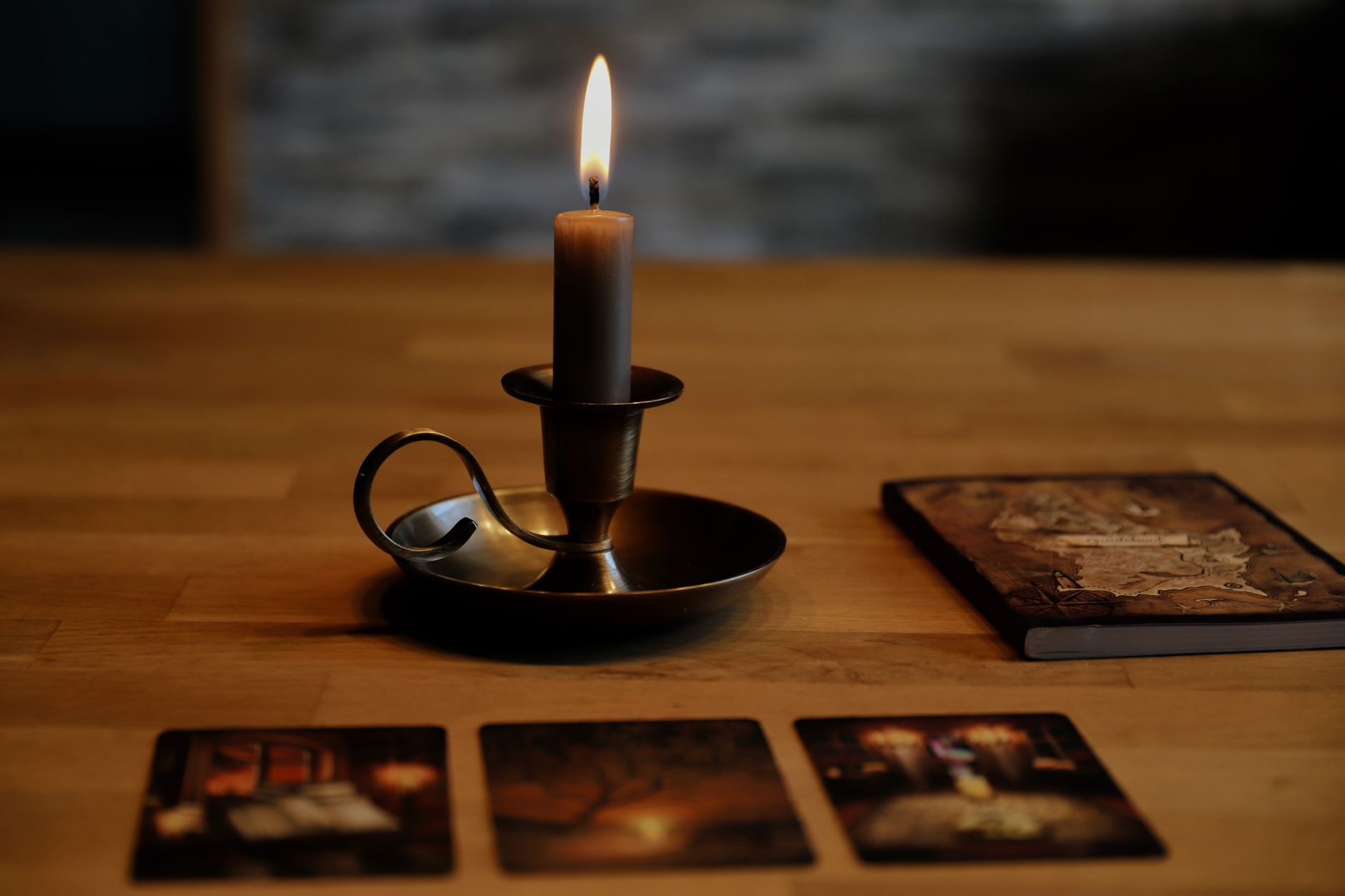Tarot cards and a lit candle arranged on a table before a psychic reading